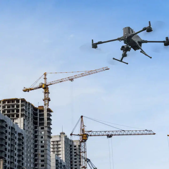 DJI Matrice 400 drone flying over construction site with cranes and buildings under development.