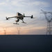 DJI Matrice 400 drone flying against a sunset backdrop with power lines in the background.
