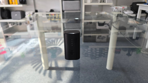 Pre-Owned DJI FPV Avata goggles battery displayed on a glass table in a modern store setting.
