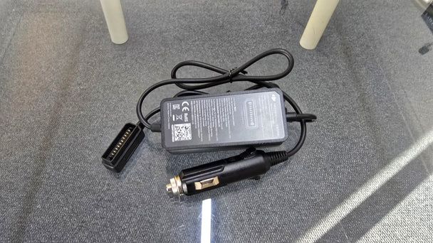 Pre-Owned DJI Mavic 2 car charger with cable on a surface, ideal for charging drones on the go.