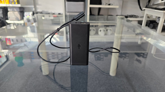 Pre-Owned Mavic Air AC Charger with cable on a glass table, ideal for DJI drone enthusiasts.