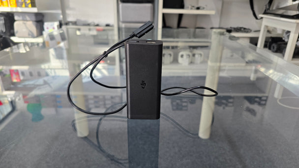 Pre-Owned Mavic Air AC Charger with cable on a glass table, ideal for DJI drone enthusiasts.