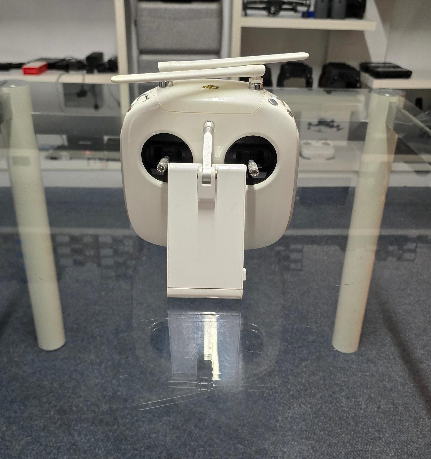 Pre-Owned DJI Phantom 4 Pro V2 Controller displayed on a glass table with no background distractions.